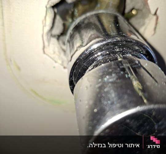 צינור מתכת עם חור בקיר, נזילה אפשרית